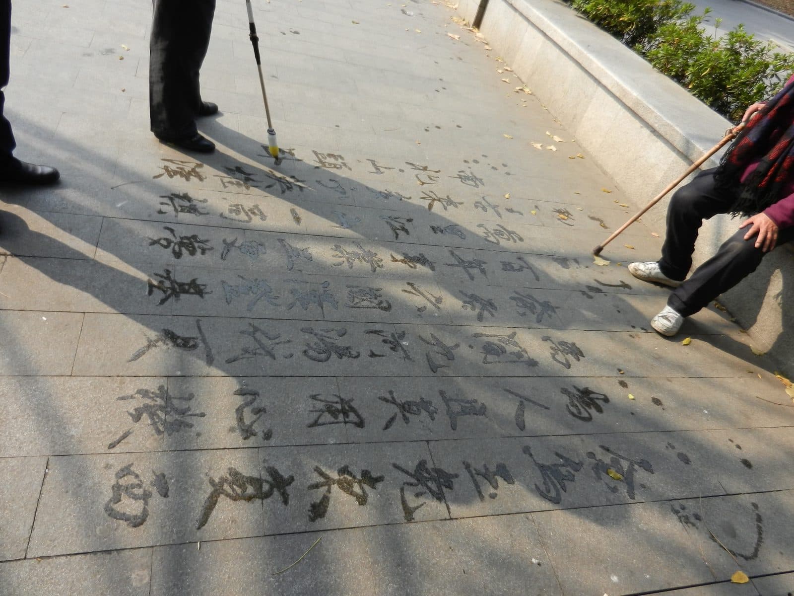 Chinese calligraphy written in water on park paving stones in Shanghai